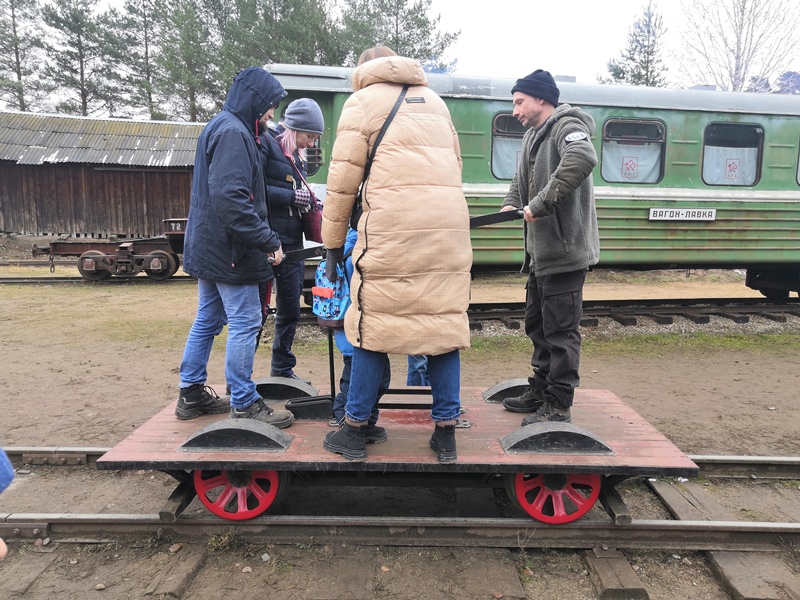 На этой маленькой четырехколесной дрезине на обращенной в две стороны двойной скамейке защищенные